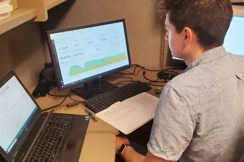 Engineer analyzing data and performing electrical and mechanical engineering tasks on computer